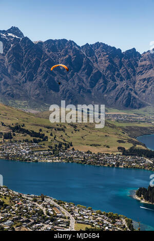 Luftaufnahme eines Gleitschirms absteigend über Queenstown, Neuseeland mit Lake Wakatipu unter einem blauen Himmel Stockfoto