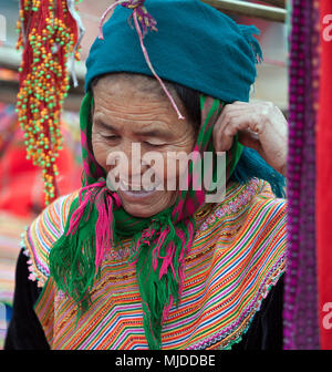 Frau gekleidet in traditionelle Stammes- Kleid mit Perlen und Webereien im Can Cao Markt in der Nähe von Sapa, Vietnam. Stockfoto