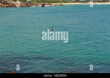 Man Stand up Paddeln im Meer. Praia do Rosa, Brasilien Stockfoto