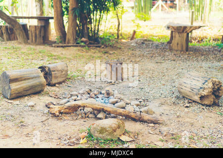 Das Holz Bänke rund um den Stein und Fels Feuerstelle. Stockfoto