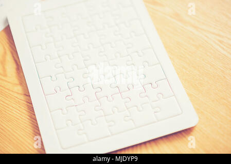 White jigsaw auf Business Desktop Tabelle Stockfoto