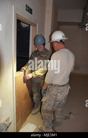 CAMP BUEHRING, Kuwait-SPC. Tyler James von Oklahoma City überprüft, ob die neue Wand Level ist beim SPC. Thomas Hart Stroud, Okla., hält das Licht für ihn. Beide Soldaten sind mit der 2120Th Engineer Company, 458th Engineer Battalion, 35th Engineer Brigade, Task Force spartanisch, und ein Teil der Ingenieur Bau Projekt im Irak. (U.S. Armee Stockfoto