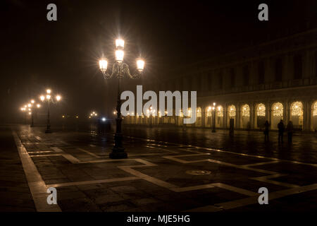 St Mark's Square/Piazza San Marco in Venedig am Abend während der Weihnachtszeit, die stimmungsvolle Beleuchtung auf der fast menschenleeren Platz und in den Arkaden Stockfoto