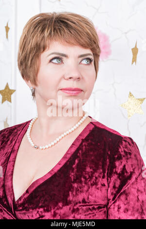 Nahaufnahme Porträt einer mittleren Alters business Frau in einem Kleid Burgund Stockfoto