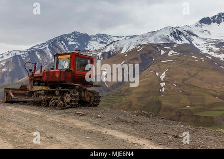 Alte sowjetische Caterpillar Tractor im Hintergrund der schneebedeckte Berge Stockfoto