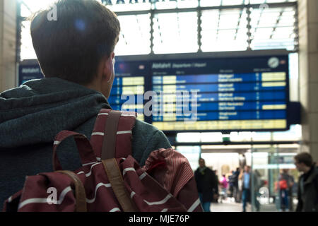 Junger Mann vor Ziel board im Bahnhof Stockfoto