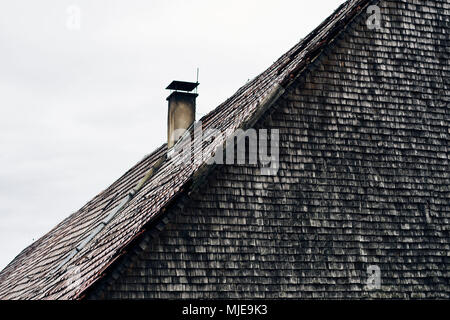 Dach mit Ziegel und Kamin, alten Schindeln, graue und verwitterte auf ein Holzhaus im Schwarzwald Stockfoto