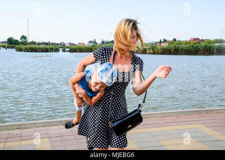Mutter und Sohn spielen auf der Seepromenade. Gehen Mutter und Sohn. Stockfoto