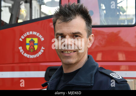 30 April 2018, Delmenhorst, Deutschland: Holger Klein-Dietz, von der Feuerwehr Delmenhorst, neben einem Löschfahrzeug. Die delmenhorster Feuerwehr, ist einer der ersten Feuerwehren in Deutschland, die Atemschutzmasken für Haustiere. Foto: Carmen Jaspersen/dpa Stockfoto