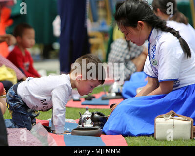 Hengyang, Hunan Provinz Chinas. 5 Mai, 2018. Eine junge Besucher sieht sich als Mitarbeiter Kaffee macht während einer im Freien Kaffee sammeln Kennzeichnung "STADTBEZIRK", den Beginn des Sommers in der chinesischen lunisolar Calendar, in Hengyang, der Central China Provinz Hunan, 5. Mai 2018. Credit: Luo Meng/Xinhua/Alamy leben Nachrichten Stockfoto