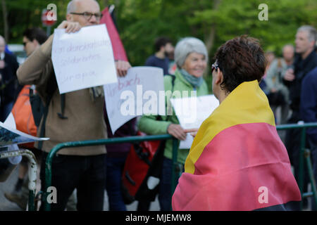 Neustadt, Deutschland. 5. Mai 2018. Ein Teilnehmer der "Patriotische März 'tragen eine deutsche Flagge über ihre Schultern Ansätze der Zähler protestieren. Die neue Hambacher Fest, organisiert von national-konservative und die Mitglieder der Neuen Rechten, fand an der Hambacher Schloss. Organisiert von umstrittenen Christlich Demokratische Union Deutschlands) Mitglied und Alternative für Deutschland) Sympathisant Max Otte, sieht umstrittene Redner wie Thilo Sarrazin, Vera Lengsfeld und Sprecher des Bundes für die AfD Jörg Meuthen. Quelle: Michael Debets/Alamy leben Nachrichten Stockfoto