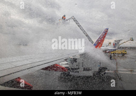 Detroit, Michigan - ein Arbeitnehmer sprays Enteisungsflüssigkeiten auf einem Southwest Airlines Jet vor einem Flug vom Flughafen Detroit Metro. Stockfoto