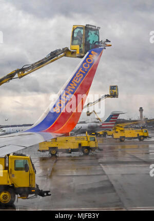 Detroit, Michigan - Arbeitnehmer spray Enteisungsflüssigkeiten auf airliners vor dem Abflug vom Flughafen Detroit Metro. Stockfoto