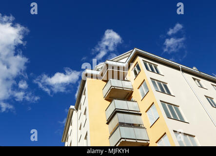 Schwedische Modernes Mehrfamilienhaus gegen den blauen Himmel mit Wolken. Stockfoto