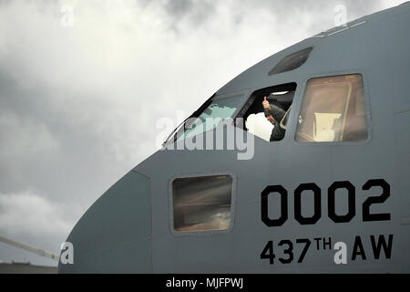 Us Air Force Master Sgt. Joseph Burris, 145 Aircraft Maintenance Squadron, sitzt im Pilotensitz eines C-17 Globemaster III Flugzeuge für einen hohen Aussichtspunkt, alle Hindernisse zu erkennen, während die Zelle in den Haken auf der North Carolina Air National Guard (NCANG), Charlotte Douglas International Airport, 21. März 2018 gezogen. Die 437Th Airlift Wing von der gemeinsamen Basis Charleston, S.C., flog in der NCANG in Transit auf die C-17 Globemaster III Flugzeuge durch die Bereitstellung ihrer Zelle zum Abschleppen Praxis in den Haken zu erleichtern. Dies ist das erste Mal eine C-17 Globemaster III Flugzeuge Biene hat Stockfoto