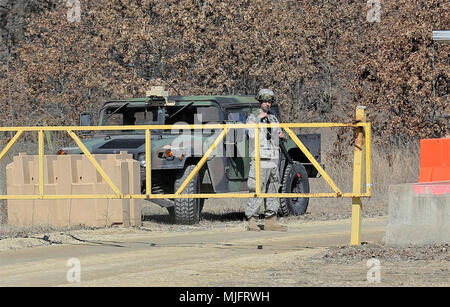 Ein Soldat am Fort McCoy, Wis., für die Ausbildung im Kampf Support Training (CSTX) 78-18-03 und den Regionalen Medic übung Uhren über ein Tor auf eine bessere taktische Schulung Base Freiheit auf North Post bei der Installation am 22. März 2018. CSTX 78-18-03 ist eine Übung, die von der 78-Ausbildungszentrum koordiniert, dass Armee-reserve Einheiten und Soldaten ausgebildet sind und bereit, auf kurze bereitstellen - Bekanntmachung und fähig, Bekämpfung bereit, und tödlichen Feuerkraft zur Unterstützung überall in der Welt der Armee und der gemeinsamen Partner. Er regionale Medic Übung konzentriert sich auf synchronisiert expeditionary Gesundheit Stockfoto