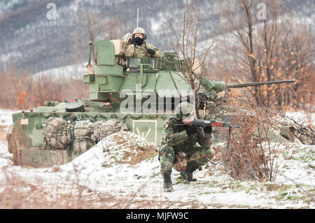 Einen bulgarischen Soldaten bis zum 42. mechanisierten Infanteriebataillon zugeordnet verteidigt ein primäres Ziel Punkt neben einem U.S. Army Bradley Crew während der Partnerschaft mit US-Soldaten zu Unternehmen B zugewiesen sind, 1.Bataillon, 18 Infanterie Regiment, 2. gepanzerte Brigade Combat Team, 1.Infanterie Division, in Novo Selo, Bulgarien, 23. März 2018. Die beiden Alliierten in einem Zweitägigen gemeinsamen Training unter dem Kommando und Kontrolle der Bulgarischen Oberstleutnant Ivaylo Ivanov teilgenommen, bataillonskommandeur des 42. mechanisierten Infanteriebataillon. (U.S. Armee Stockfoto