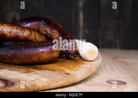 Gebratene Würstchen auf einem Holzbrett Stockfoto