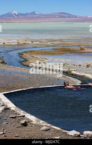 TUPIZA, Bolivien - September 23, 2011: ein Mann, der Entspannung in den heissen Quellen von Salar de Uyuni und genießen Sie die atemberaubende Wüstenlandschaft Stockfoto