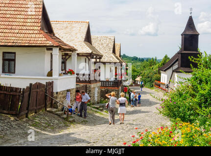 Besucher schlendern Sie entlang des Kossuth Street in der UNESCO World Heritage Village - Holloko, Ungarn Stockfoto