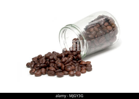 Kaffee Bohnen verschütten aus einem cristal Glas auf weißem Hintergrund Stockfoto