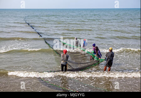 Filipino Fischer ziehen ihre seine Net am Baybay Strand, Roxas City, Panay Island, Philippinen zum Ufer. Stockfoto