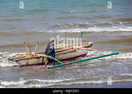 Ein einsamer Filipino fisherman Köpfe heraus zum Meer in seiner Ein-Mann-bangka (paraw - parao), ein Boot mit zwei Bambus Stützen aus Baybay Strand auf der Stockfoto