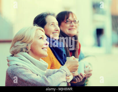 Gruppe von senior Freundinnen Teetrinken am Balkon und lächelnd. Blondine im Fokus Stockfoto