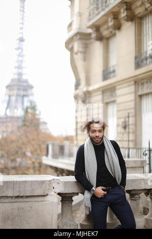 Afro-amerikanische männliche Person in der Nähe von Beton Geländer mit Eiffelturm in Paris. Stockfoto
