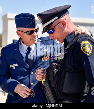 Pensionierte Oberst Allen Davis, Sohn von Oberst Edgar "Felton' Davis, Umarmungen Goldsboro Polizeioffizier Tim Christie nach seiner Internierung Zeremonie am 6. April 2018, am östlichen Carolina State Veteran-kirchhof in Goldsboro, North Carolina. Christie trug Oberstleutnant Edgar "Felton' Davis' Kriegsgefangenen/in Aktion Armband fehlt für mehrere Jahre und kehrte das Armband an Colonel Allen Davis. (U.S. Air Force Stockfoto