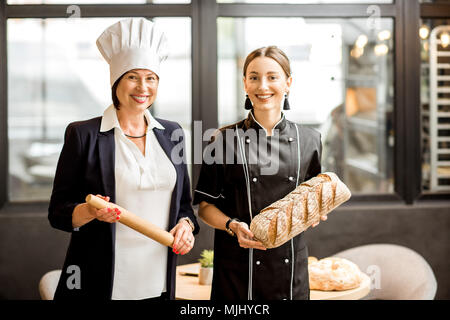 Senior Chef Konditor mit jungen Assistenten in der Bäckerei Stockfoto