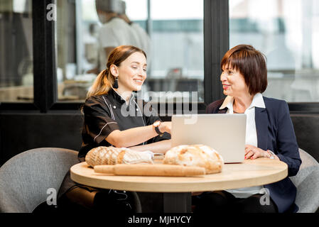 Mit jungen Koch in der Cafe Geschäftsfrau Stockfoto