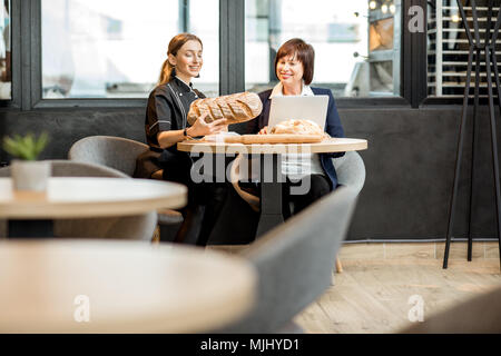Mit jungen Koch in der Cafe Geschäftsfrau Stockfoto
