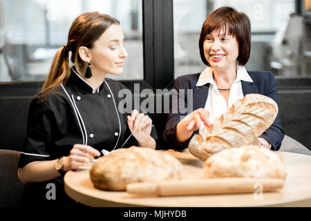 Senior Chef mit jungen Bäcker in der Bäckerei Stockfoto