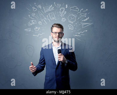 Geschäftsmann sprechen in das Mikrofon mit gemischten Doodles über seinem Kopf Stockfoto