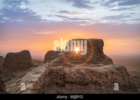 Die Strahlen der aufgehenden Sonne Permeat durch die Ruinen des antiken Ayaz Kala in der kyzylkum Wüste, Usbekistan Stockfoto