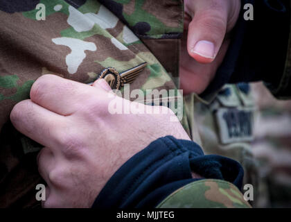 Ein Deutscher jump master Pins springen Flügel seines Landes auf ein US-Soldat, nachdem er Airborne Operations bei Sizilien Drop Zone während des 20. jährlichen Randy Oler Memorial Betrieb Spielzeug Fallen, Dez. 2, 2017 abgeschlossen. Betrieb Spielzeug Fallen, bewirtet durch die US-Armee die zivilen Angelegenheiten&amp; psychologische Operations Command (Airborne) und ist die größte kombinierte Betrieb weltweit durchgeführt. Die Veranstaltung und der Soldaten erlaubt, die Möglichkeit, auf ihren militärischen beruflichen Spezialgebiet zu trainieren, pflegen ihre Bereitschaft, in die Luft und wieder zurück in die lokale Gemeinschaft zu geben. (U.S. Armee Foto: Staff Sgt. Timothy R. Koster) Stockfoto