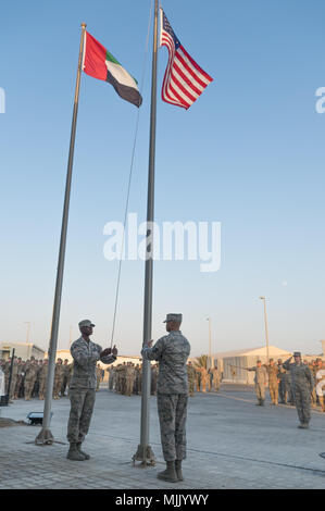 Flieger von der 380 Air Expeditionary Wing Ehrengarde niedriger der US-Flagge während der 380 Air Expeditionary Wing retreat Zeremonie, Dez. 1, 2017 Al Dhafra Air Base, Vereinigte Arabische Emirate. Die 380 AEW hält eine monatliche Wing-weiten Rückzug Zeremonie zu Ehren der US-service Mitglieder in Aktion während des vorhergehenden Monats getötet. (U.S. Air National Guard Foto: Staff Sgt. Colton Elliott) Stockfoto