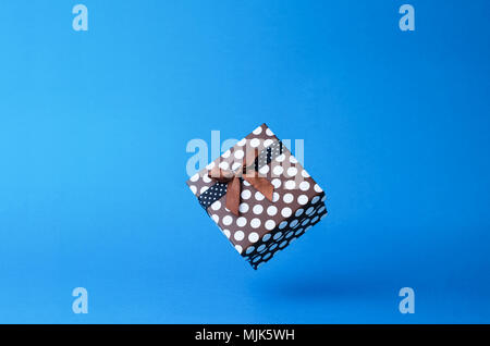 Geschenkbox mit Punkten, die in der Luft schweben über blauen Hintergrund mit Kopie Raum Stockfoto