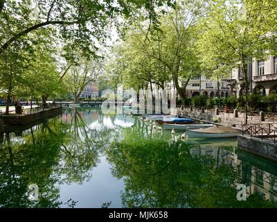 Baum beschattet, malerischen alten Kanal mit ein paar kleinen, angelegte Boote mit Wasser Reflexionen in Annecy, Frankreich Stockfoto