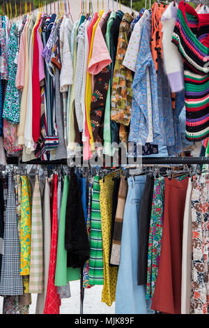 Alte Vintage Kleidung der Frauen zum Verkauf auf einem Rack zu einem retro vintage car boot Sale. Getreidespeicher Square, Kings Cross, London Stockfoto