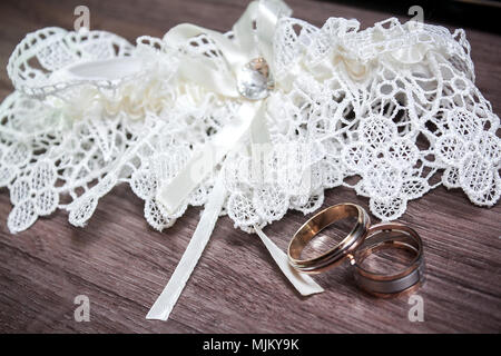 Hochzeit. Dekor. Der Braut Schuhe, eine schöne Hochzeit Bouquet, Ringe, Anstecker und Schmuck schön auf einem grauen Hintergrund Holz gelegt werden. Nach oben V Stockfoto