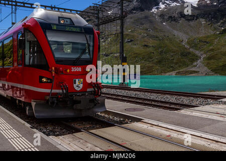 Poschiavo, Graubünden, Schweiz - 10 AUGUST 2016: Rote Zug der Rhätischen Bahn in die Station Ospizio Bernina auf 2253 m an einem sonnigen Tag in Stockfoto