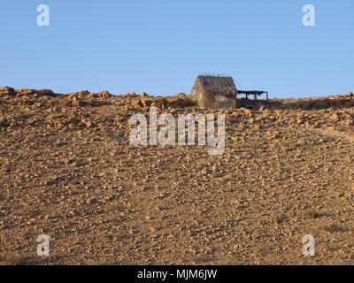 Kleine Stroh Haus in der Wüste gesehen aus der Ferne, unter strahlend blauem Himmel Stockfoto