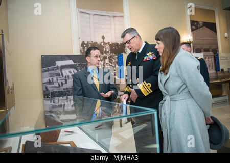 Tim Frank (links), Historiker, Arlington National Cemetery bietet eine Führung durch die Gedenkstätte Amphitheater Anzeige Zimmer zum stellvertretenden Leiter der Australian Defence Force, Vice Adm. Ray Griggs (Mitte), und sein Ehegatte, Chloe (rechts), auf dem Arlington National Cemetery, Arlington, Virginia, Dez. 7, 2017. Griggs teilgenommen haben früher in einem bewaffneten Kräfte die volle ehrt Wreath-Laying Zeremonie am Grab des Unbekannten Soldaten. (U.S. Armee Foto von Elizabeth Fraser/Arlington National Cemetery/freigegeben) Stockfoto