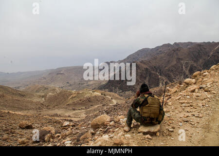 Afghanische 8. Sondereinsätze Kandak-Kommandos dienen als spezialisierte leichte Infanterie-Formation in Afghanistan. Am 11. Dezember 2017 führte ein Kommando Frühwarndienste aus bergigem Gelände im Wach Kot Valley in der Provinz Nangarhar durch, um die Bewegung des Konvois zu sichern. Das Archivbild dokumentiert taktische Überwachungsverfahren während laufender Sicherheitsvorgänge. Stockfoto