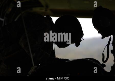 SCHOFIELD Kasernen, Hawaii-SPC. Logan Mattix (Links), eine CH-47 Chinook Crew Chief mit dem 25 Combat Aviation Brigade, und Chief Warrant Officer 3 Gregory Benson (Rechts), einen fallschirmabwurf Systeme Techniker mit dem 25 Sustainment Brigade, bereiten einen manipulierten low cost Low Altitude (LCLA) Last bei Kahuku Training Area 12 Dezember fallen zu lassen, während eine Lieferung. Die LCLA Lieferung Methode wird am Boden Truppen bei weniger Kosten und höhere Genauigkeit als eine der großen Höhe airdrop ist die bevorzugte Methode für leichte Verbrauchsmaterialien zu versorgen. (U.S. Armee Foto von Sgt. Ian Ives, 25 S Stockfoto