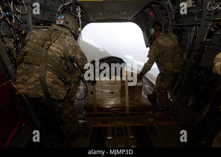 SCHOFIELD Kasernen, Hawaii-SPC. Logan Mattix (Links), eine CH-47 Chinook Crew Chief mit dem 25 Combat Aviation Brigade, und Chief Warrant Officer 3 Gregory Benson (Rechts), einen fallschirmabwurf Systeme Techniker mit dem 25 Sustainment Brigade, bereiten einen manipulierten low cost Low Altitude (LCLA) Last bei Kahuku Training Area 12 Dezember fallen zu lassen, während eine Lieferung. Die LCLA Lieferung Methode wird am Boden Truppen bei weniger Kosten und höhere Genauigkeit als eine der großen Höhe airdrop ist die bevorzugte Methode für leichte Verbrauchsmaterialien zu versorgen. (U.S. Armee Foto von Sgt. Ian Ives, 25 S Stockfoto