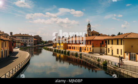 Stadtbild von Gaggiano, nur außerhalb von Mailand. Bunte Häuser im Kanal Naviglio Grande Wasserstraße reflektiert und absichtlich verschwommene Radfahrer Stockfoto