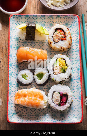 Auswahl an Sushi auf der Platte. Nigiri King Prawn. Maki mit Gurken. Nigiri Lachs, Avocado Nigiri. California Roll. Stockfoto